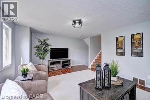 Living area featuring light gray walls, white trim, and a combination of light carpet and wood-finish flooring - 175 David Bergey Drive Unit# L74, Kitchener, ON - Indoor Photo Showing Living Room
