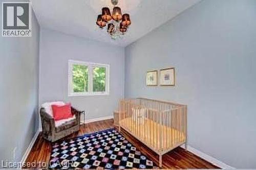 Room featuring wood-finish flooring, a contemporary chandelier, light-colored walls, and a window with exterior views - 175 David Bergey Drive Unit# L74, Kitchener, ON - Indoor