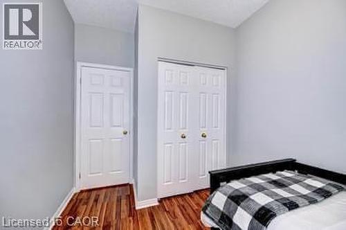Wood-finish flooring with white baseboards throughout - 175 David Bergey Drive Unit# L74, Kitchener, ON - Indoor Photo Showing Bedroom