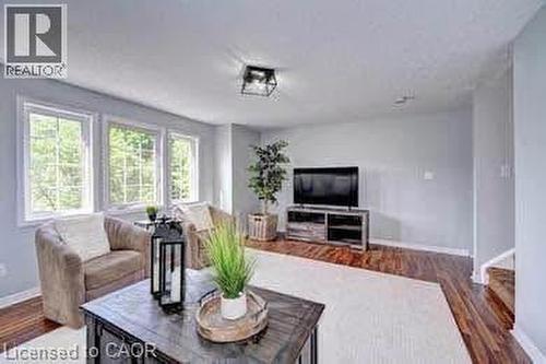 Living area featuring rich wood-finish flooring, light gray wall tones, and abundant natural light from multiple windows - 175 David Bergey Drive Unit# L74, Kitchener, ON - Indoor Photo Showing Living Room