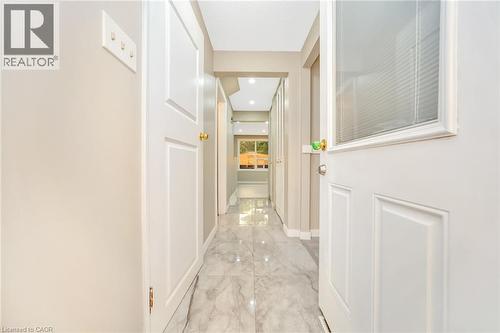 Hallway featuring polished tile flooring, recessed lighting, white paneled doors, and a partial glass door with integrated blinds - 53 Burns Drive, Guelph, ON - Indoor Photo Showing Other Room