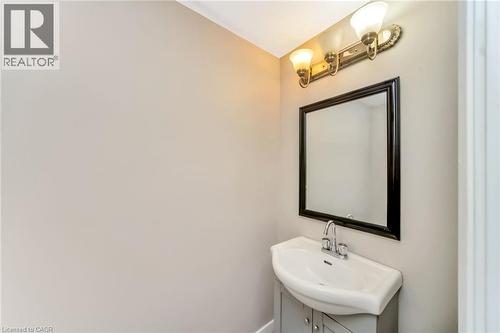 Pedestal sink vanity with a chrome faucet, framed mirror, and dual-bulb light fixture - 53 Burns Drive, Guelph, ON - Indoor Photo Showing Bathroom