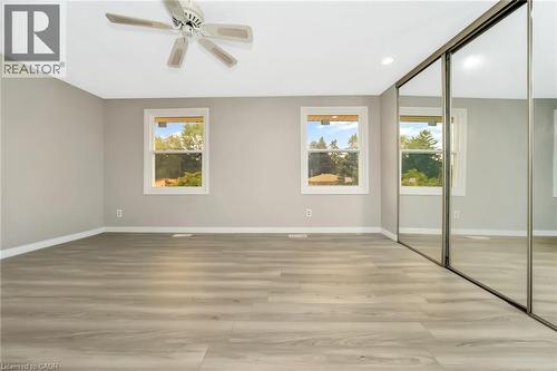 Spacious room featuring wood-finish flooring, light grey walls, and a white ceiling with a ceiling fan - 53 Burns Drive, Guelph, ON - Indoor Photo Showing Other Room