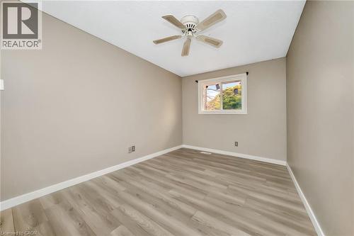 Spacious room with wood-finish flooring, neutral-toned walls, and a white ceiling with a ceiling fan - 53 Burns Drive, Guelph, ON - Indoor Photo Showing Other Room