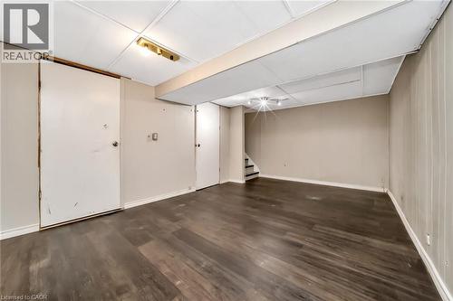 Spacious room featuring dark wood-finish flooring, light neutral-toned walls, and a drop-tile ceiling with recessed lighting - 53 Burns Drive, Guelph, ON - Indoor