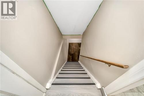 Stairwell featuring wood-finish treads with dark risers, a light wood handrail, and neutral-toned walls - 53 Burns Drive, Guelph, ON - Indoor Photo Showing Other Room