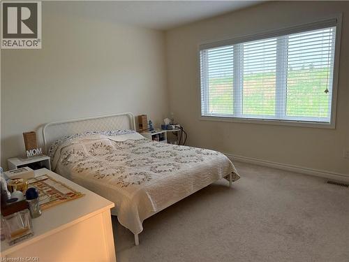Bright bedroom featuring neutral wall tones and a large window with horizontal blinds - 63 Ridge Road, Cambridge, ON - Indoor Photo Showing Bedroom