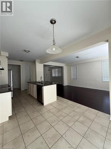 Kitchen island with dark countertop and integrated sink, complemented by light tile flooring - 63 Ridge Road, Cambridge, ON - Indoor