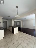 Kitchen island with dark countertop and integrated sink, complemented by light tile flooring - 