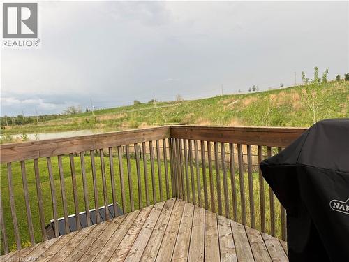 Outdoor wood deck with railing overlooking a pond and green landscape - 63 Ridge Road, Cambridge, ON - Outdoor With Deck Patio Veranda