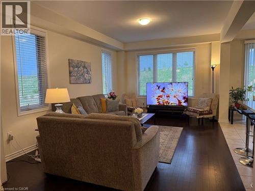 Living area featuring wood-finish flooring, multiple windows with blinds, a neutral wall color, and recessed lighting - 63 Ridge Road, Cambridge, ON - Indoor Photo Showing Living Room
