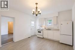 Kitchen featuring white cabinetry, light-toned countertops, and a full suite of white appliances - 
