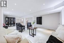 Spacious interior featuring recessed lighting, light-toned carpeting, and a built-in bookshelf with glass doors - 