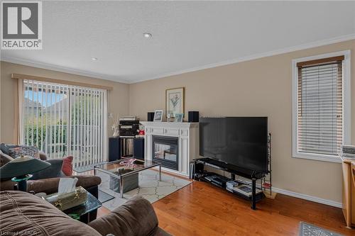 hardwood flooring gas fireplace sliding door to 10 x 10 deck - 49 Millcroft Drive, Simcoe, ON - Indoor Photo Showing Living Room With Fireplace