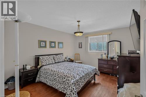 hardwood flooring closets bright window - 49 Millcroft Drive, Simcoe, ON - Indoor Photo Showing Bedroom