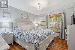 Spacious principal bedroom with wood flooring. - 