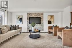 Living area featuring a textured accent wall, recessed lighting, and patterned carpeting - 