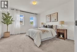 Bright bedroom featuring two windows, neutral carpeting, and a built-in ceiling light fixture - 