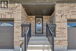 Brick facade featuring a covered entryway with concrete steps and black railings - 