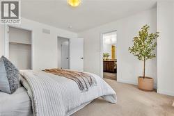 Carpeted bedroom featuring white walls and a ceiling-mounted light fixture - 