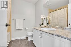 Bathroom featuring a white vanity with a light-toned countertop, an integrated sink, and chrome fixtures - 