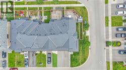 Townhome complex featuring dark grey roofing and private backyards - 