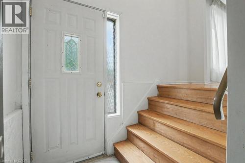 Entryway featuring a paneled door with decorative glass insert and a sidelight, alongside wood-finish stairs with a coordinating handrail - 396 Pinemeadow Avenue, Mississauga, ON - Indoor Photo Showing Other Room