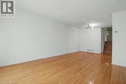 Spacious room featuring wood-finish flooring and a contemporary black ceiling fixture - 396 Pinemeadow Avenue, Mississauga, ON - Indoor Photo Showing Other Room