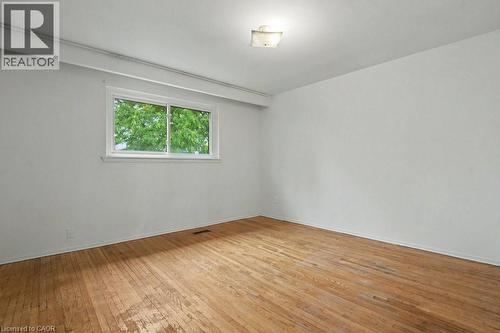 Light-filled interior space featuring wood-finish flooring, white walls, and a white framed window - 396 Pinemeadow Avenue, Mississauga, ON - Indoor Photo Showing Other Room