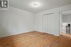 Hardwood flooring throughout, featuring a bi-fold closet and flush-mount ceiling light - 