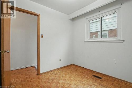 Bright room featuring a parquet wood-finish floor, a large window with white trim, and a white interior door frame - 396 Pinemeadow Avenue, Mississauga, ON - Indoor Photo Showing Other Room