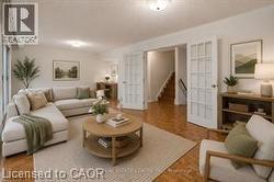 Living area featuring wood-finish flooring, white walls, and recessed lighting - 