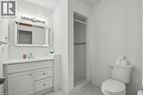 Bathroom featuring a single vanity with storage, a rectangular mirror, and a walk-in shower with decorative tile accent - 396 Pinemeadow Avenue, Mississauga, ON - Indoor Photo Showing Bathroom