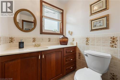 Bathroom featuring a wood-finish vanity with a built-in sink, a light-toned countertop, and a window with blinds - 7 Thomson Road, Simcoe, ON - Indoor Photo Showing Bathroom