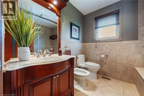 Bathroom featuring a dark wood vanity with a marble countertop, an integrated sink, and a framed mirror - 7 Thomson Road, Simcoe, ON - Indoor Photo Showing Bathroom