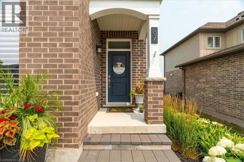 Brick facade featuring a covered porch entry with white columns - 87 Boyd Boulevard, Thamesford, ON - Outdoor With Exterior
