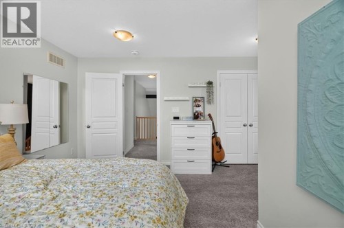 Carpeted room with light gray walls, featuring white paneled doors and a semi-flush mount ceiling light - 87 Boyd Boulevard, Thamesford, ON - Indoor Photo Showing Bedroom