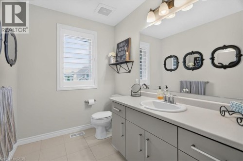 Bathroom featuring a large vanity with an integrated sink, broad wall mirror, and modern light fixture - 87 Boyd Boulevard, Thamesford, ON - Indoor Photo Showing Bathroom