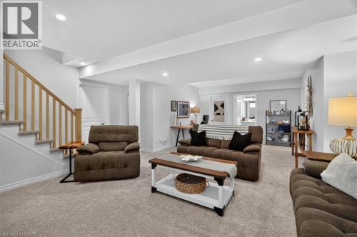Spacious finished lower level featuring recessed lighting, plush carpet flooring, a light wood-finish staircase with white risers, and white trim throughout - 87 Boyd Boulevard, Thamesford, ON - Indoor Photo Showing Living Room