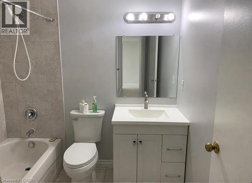 Bathroom featuring a white vanity with integrated sink, brushed nickel faucet, and coordinating mirror - 65 Highland Crescent Unit# 201, Kitchener, ON - Indoor Photo Showing Bathroom