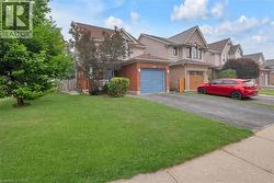 Brick and siding exterior featuring a blue garage door, front porch, and mature landscaping - 