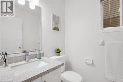 Bathroom featuring a white vanity cabinet, light-toned countertop, rectangular undermount sink, and a chrome faucet - 