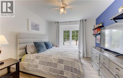 Bedroom featuring a multi-pane window, light wood-finish flooring, a ceiling fan with integrated lighting, and a contrasting accent wall - 249 Dearborn Boulevard, Waterloo, ON - Indoor Photo Showing Bedroom