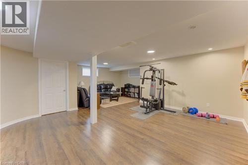 Spacious finished basement featuring wood-finish flooring, recessed lighting, and a neutral color palette - 249 Dearborn Boulevard, Waterloo, ON - Indoor Photo Showing Gym Room