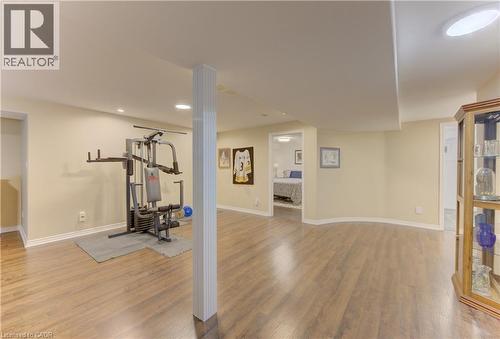 Spacious open-concept lower level featuring wood-finish flooring, recessed lighting, and a neutral color palette - 249 Dearborn Boulevard, Waterloo, ON - Indoor Photo Showing Gym Room