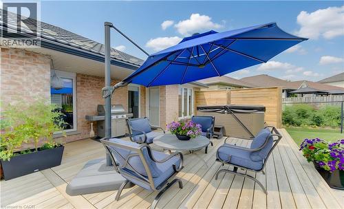 Expansive exterior deck featuring natural wood-finish planks, a built-in spa, a dedicated grilling area, and a privacy fence - 249 Dearborn Boulevard, Waterloo, ON - Outdoor With Deck Patio Veranda