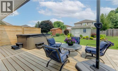 Expansive wood-finish deck featuring a built-in spa, a privacy fence, and a manicured lawn - 249 Dearborn Boulevard, Waterloo, ON - Outdoor With Deck Patio Veranda With Exterior