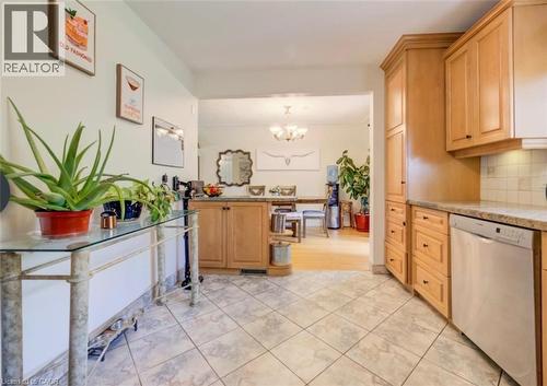 Kitchen featuring tile flooring, light wood cabinetry, stone countertops, and a stainless steel dishwasher - 209 Willowdale Avenue Unit# Upper, Waterloo, ON - Indoor Photo Showing Kitchen