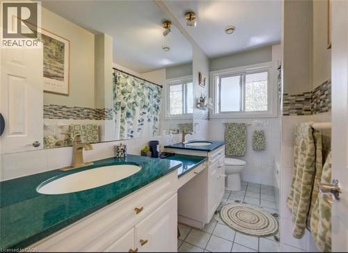 Bathroom featuring a dual vanity with green countertops, white cabinetry, and brushed gold fixtures - 209 Willowdale Avenue Unit# Upper, Waterloo, ON - Indoor Photo Showing Bathroom