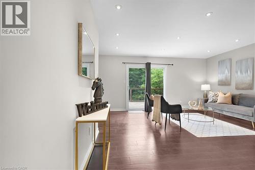 Living area featuring wood-finish flooring, recessed lighting, and a sliding glass door leading to an outdoor deck - 421 Bairstow Crescent, Waterloo, ON - Indoor Photo Showing Other Room